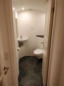 Indbydende toilet med lille håndvask